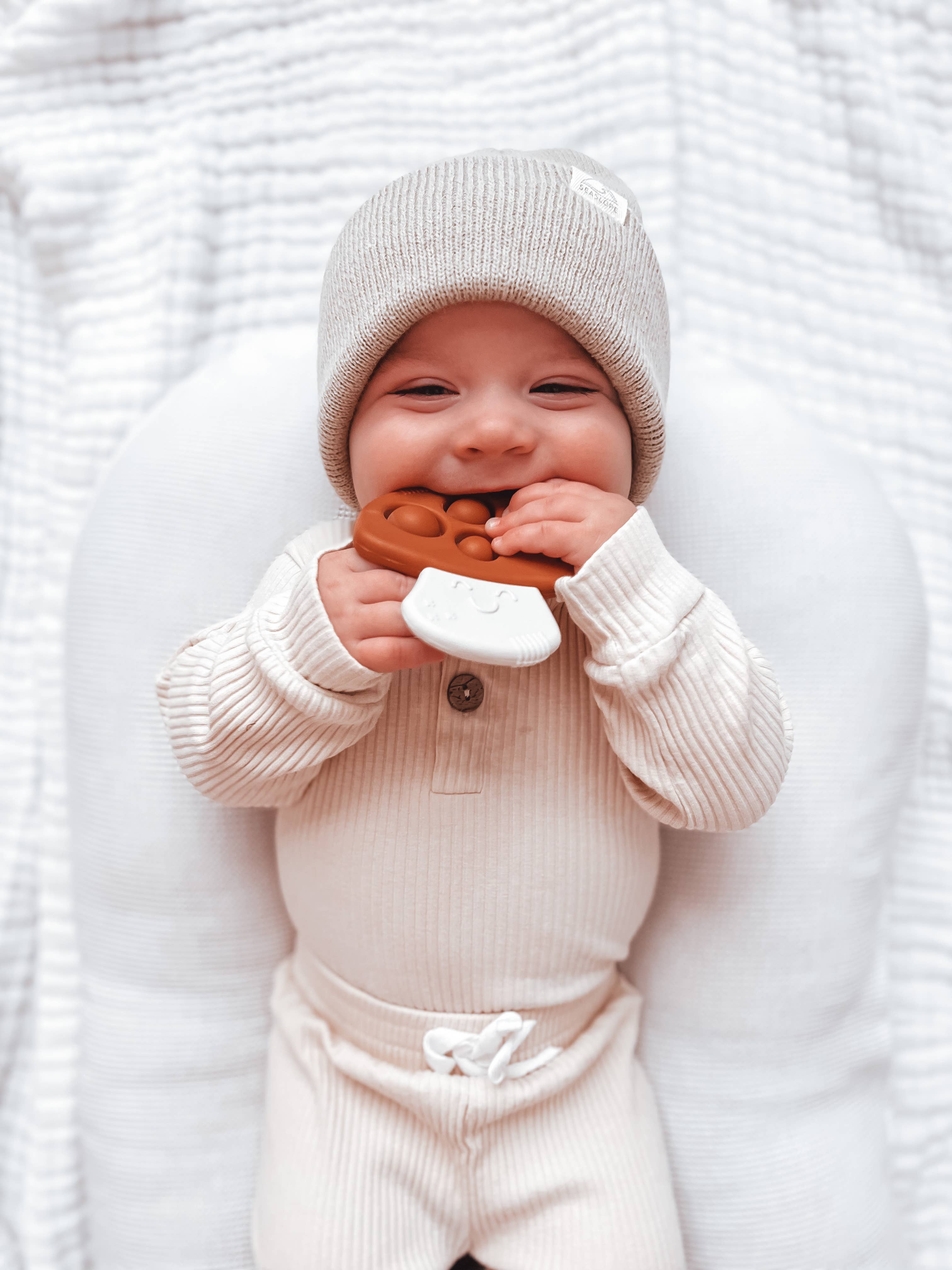 Baby enjoying Itzy Ritzy Itzy Pop Mushroom sensory teething toy, featuring soothing eco-friendly design and engaging popping sounds.