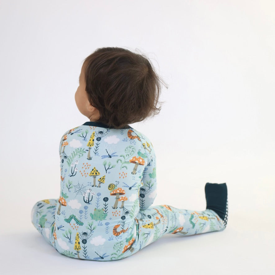 Child in colorful Critter Hollow Zipp Jammies by Rainn, showcasing a playful animal print and cozy design for comfy sleep.