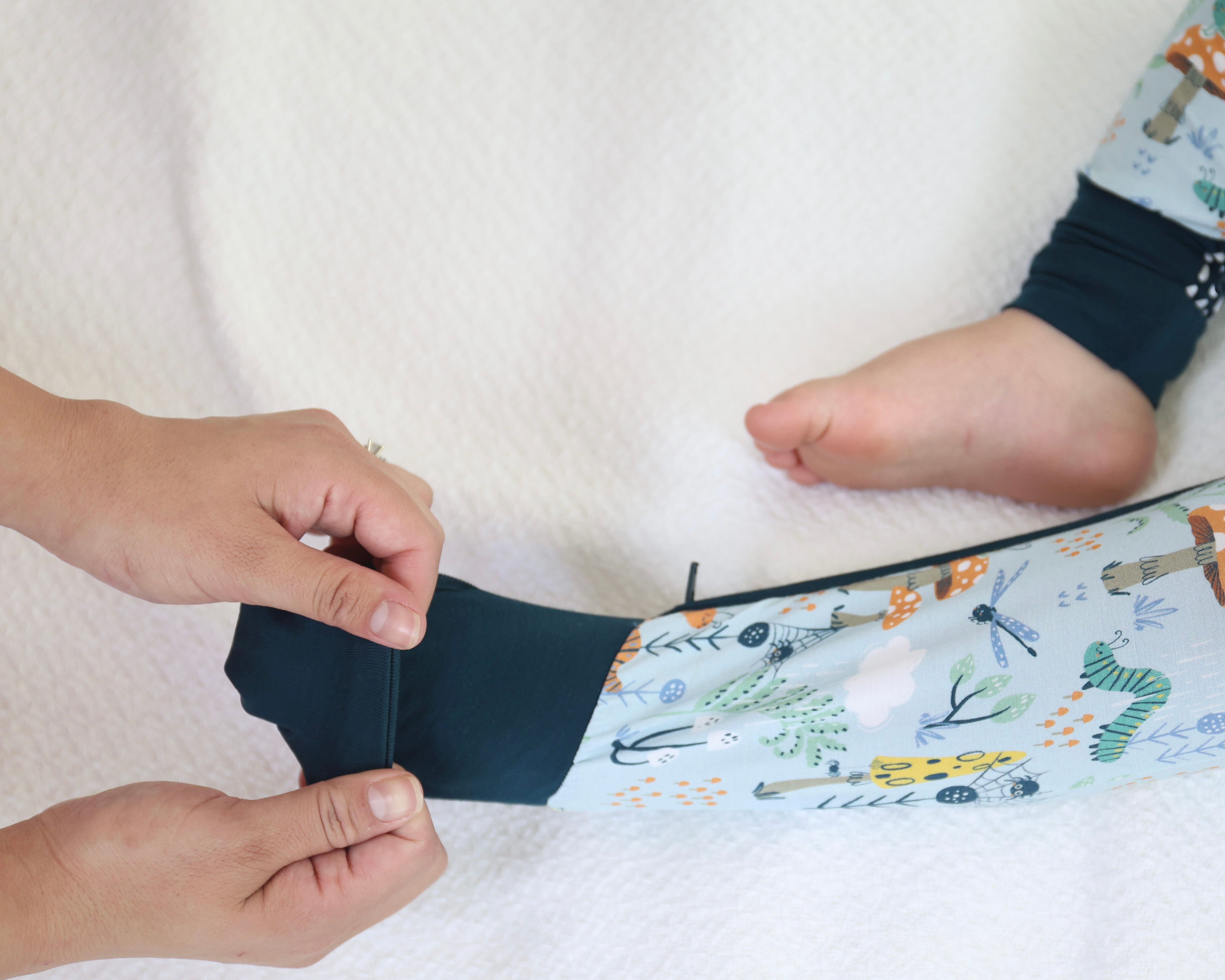 Parent adjusting a child's Critter Hollow Zipp Jammies made from soft bamboo fabric for ultimate comfort.