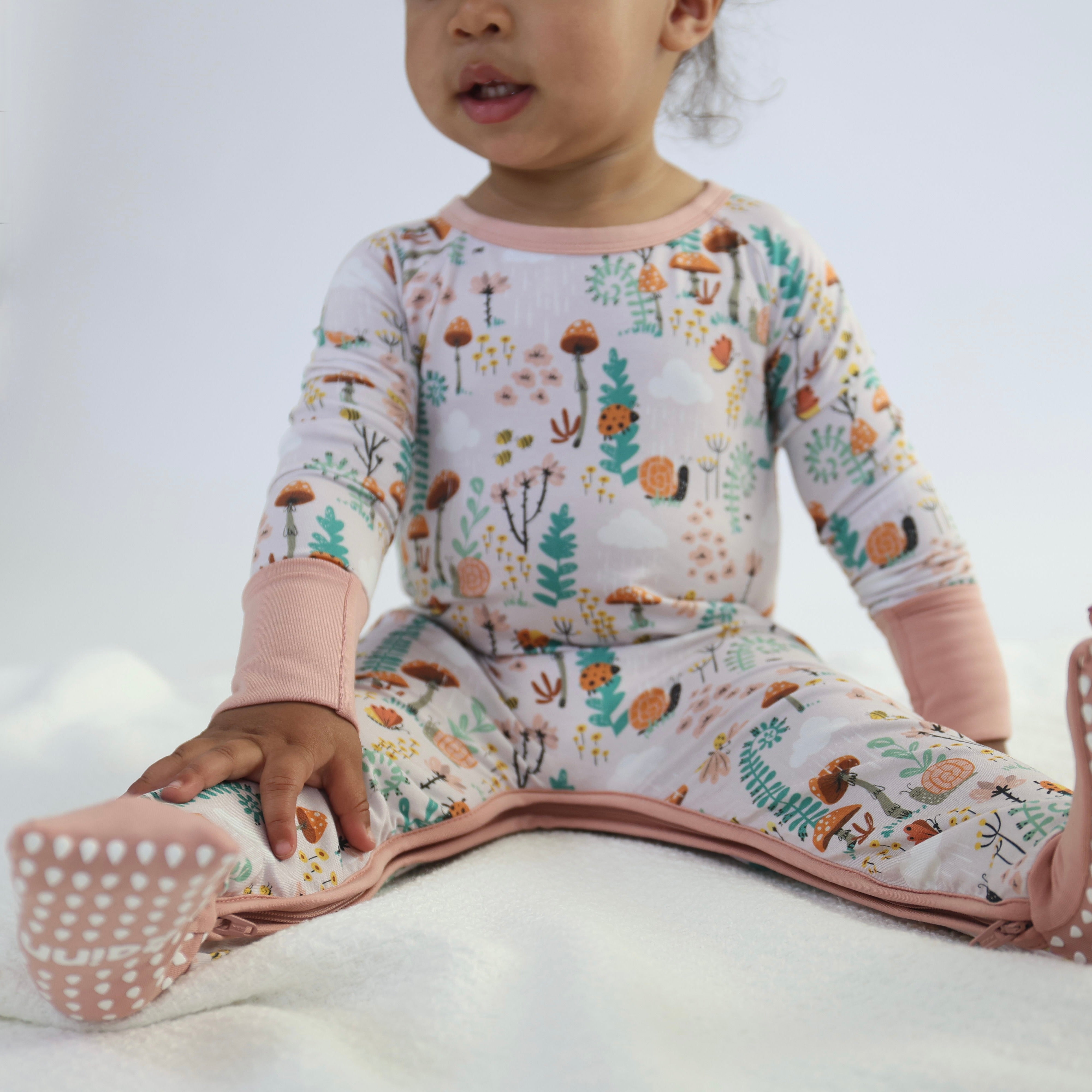 Toddler wearing Fern - Crescent Zipp Jammies, featuring a colorful botanical print and cozy design for restful sleep.
