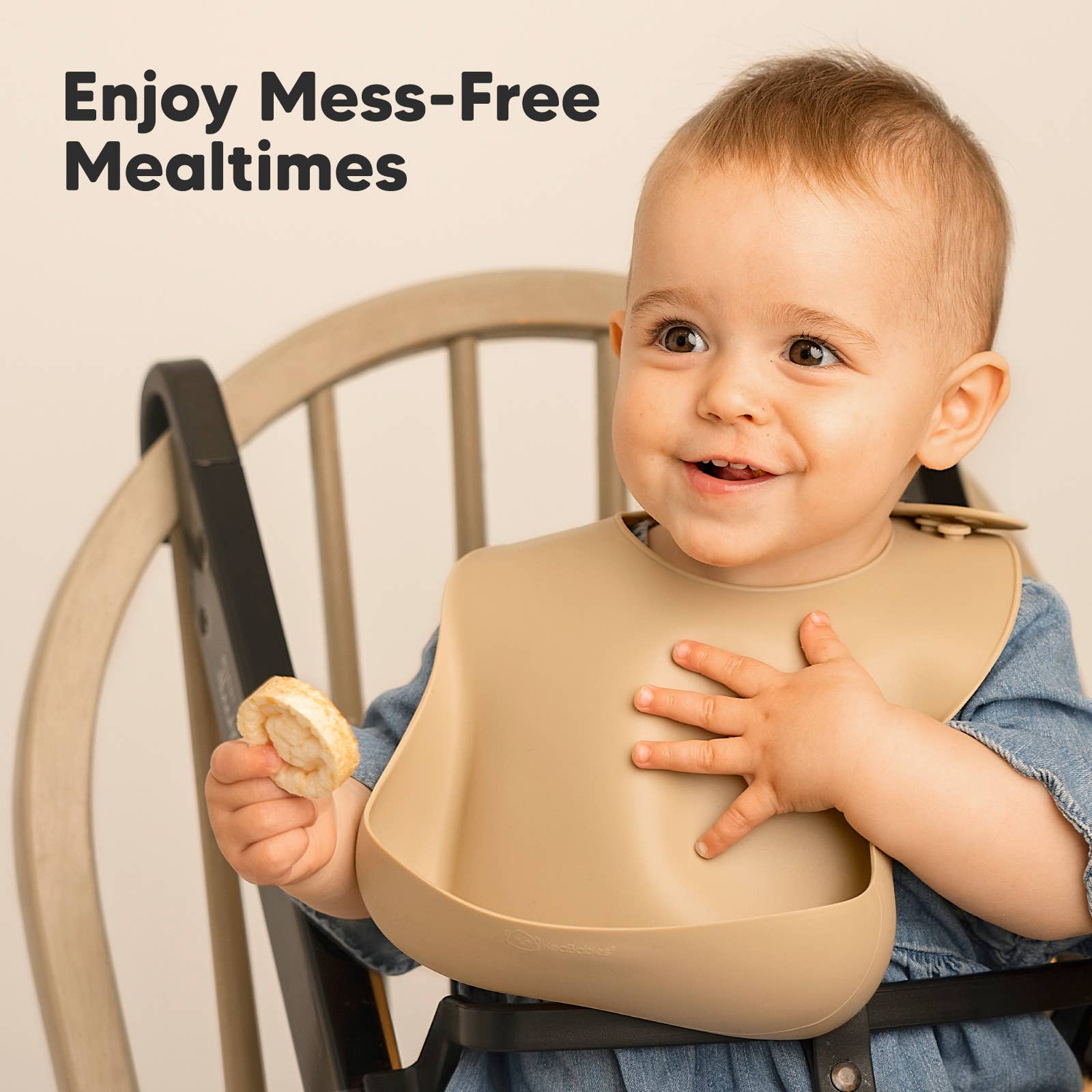 Smiling toddler wearing a soft silicone bib while enjoying a snack, perfect for mess-free mealtimes.
