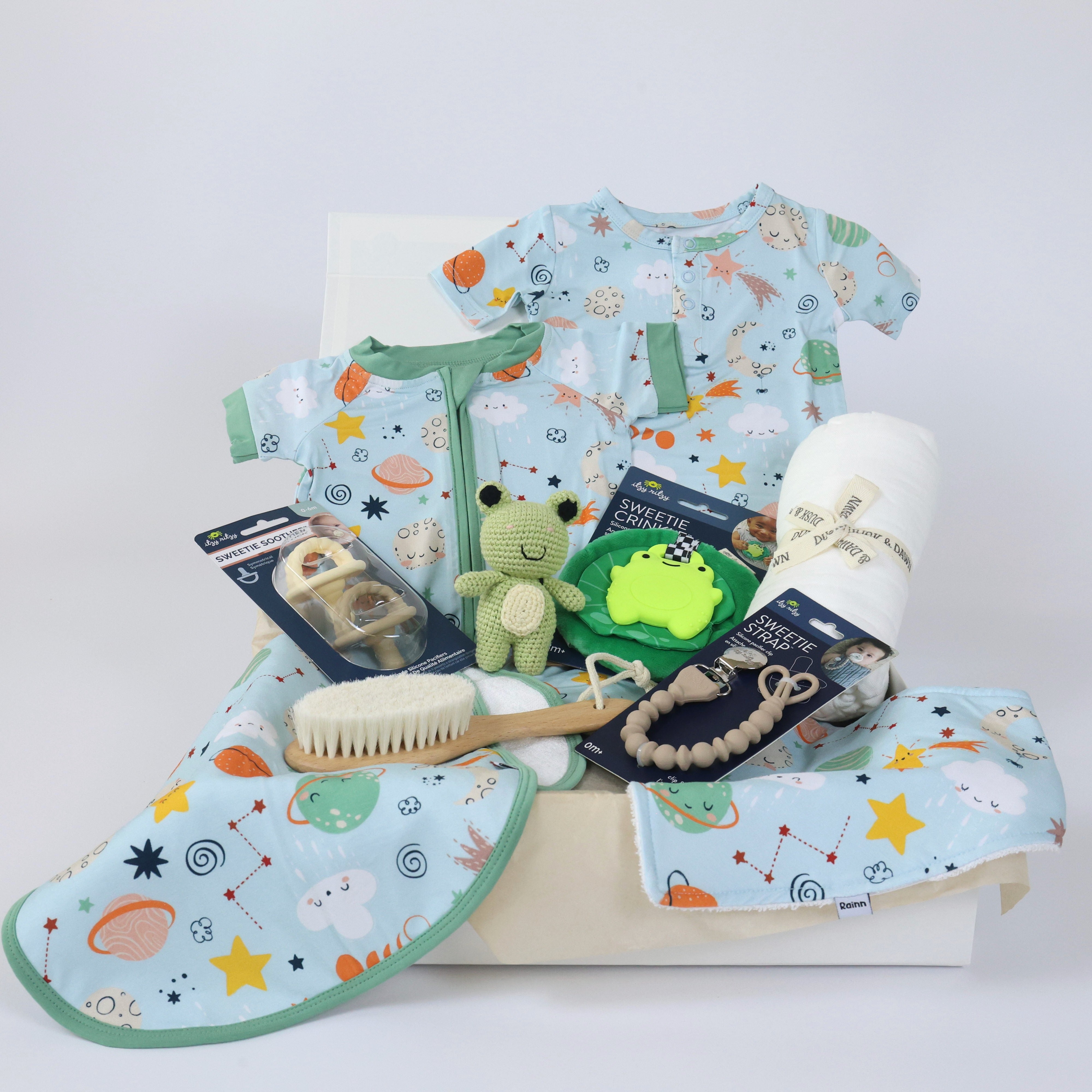 Newborn gift set for boys featuring soft eco-friendly clothes, toys, and accessories in a playful design.