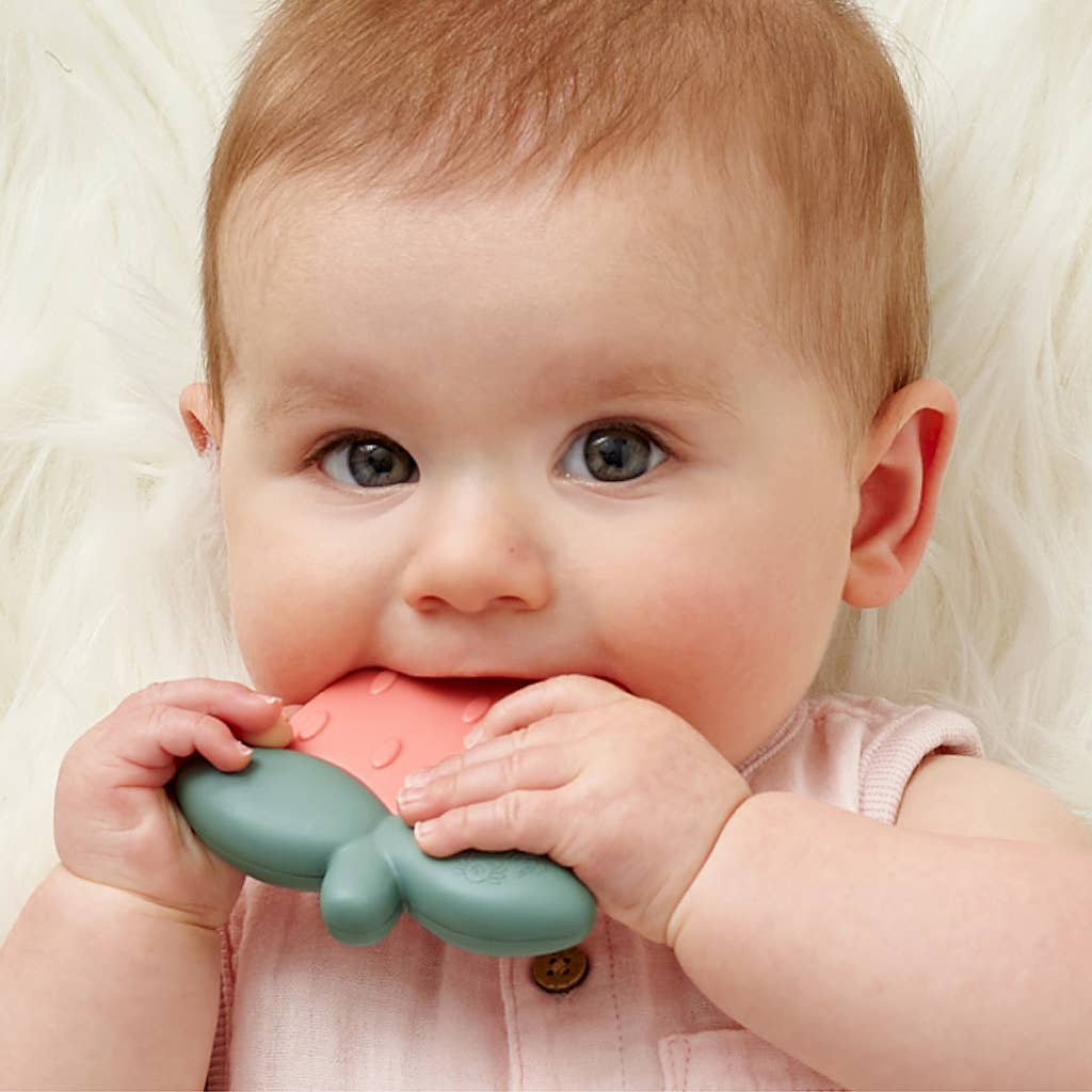 Adorable baby enjoying the Strawberry Sweetie Shake™ silicone teether for teething relief and sensory play.