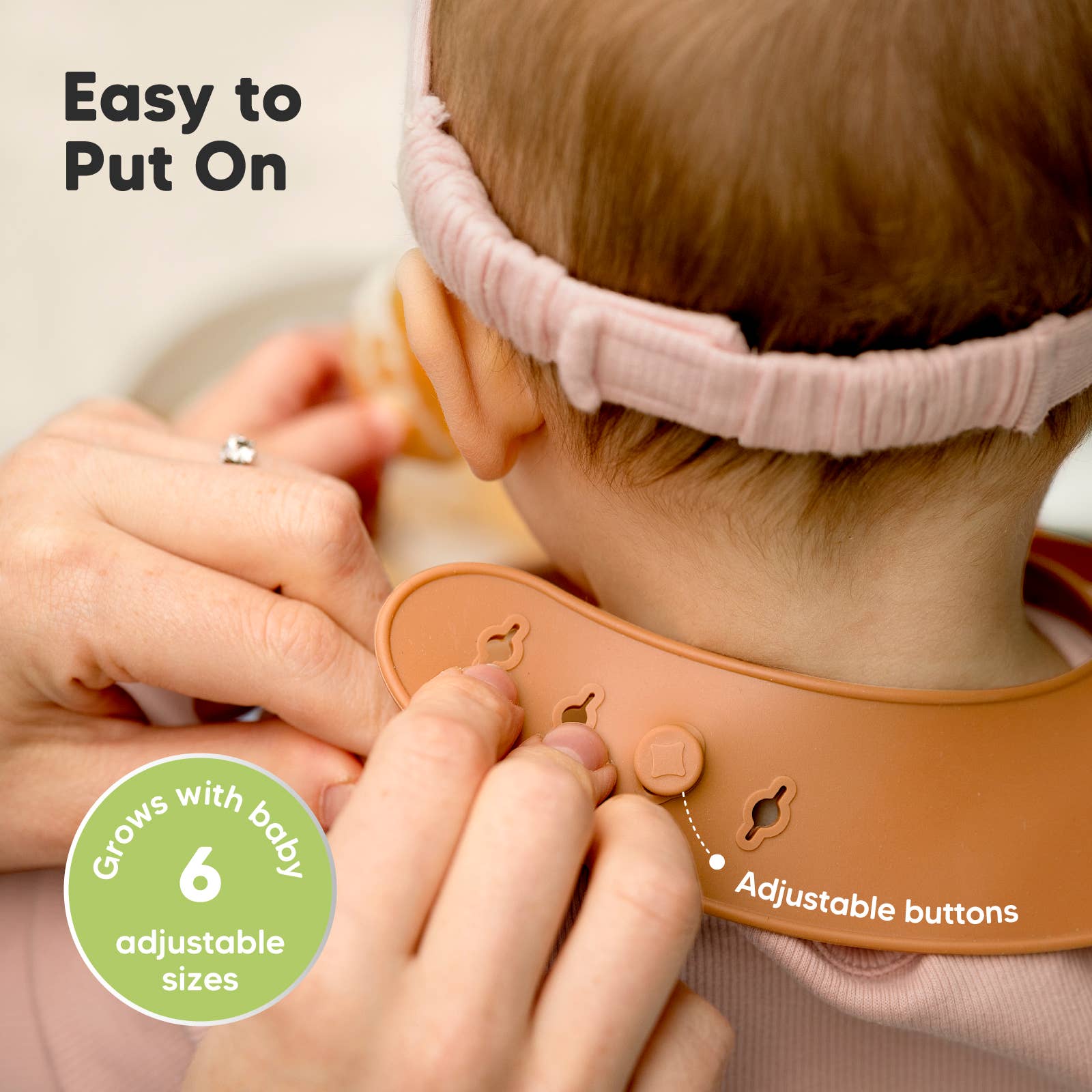 Close-up of adjustable silicone bib on baby, showing easy-on buttons and soft design for growing toddlers.