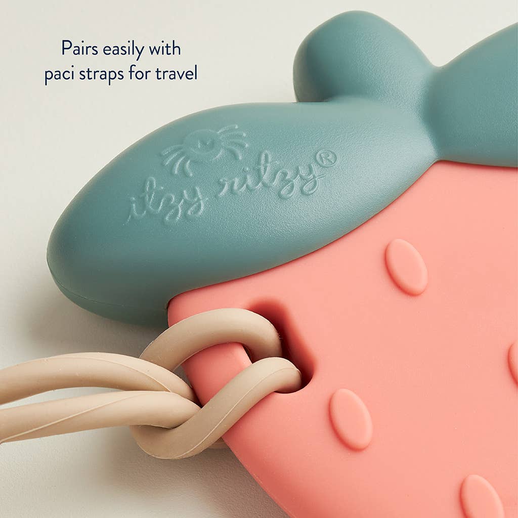 Colorful silicone Strawberry Sweetie Shake™ teether, perfect for soothing gums and easy travel with paci straps.